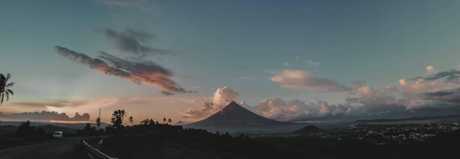 Mayon Volcano at sunrise above the green fields of Albay